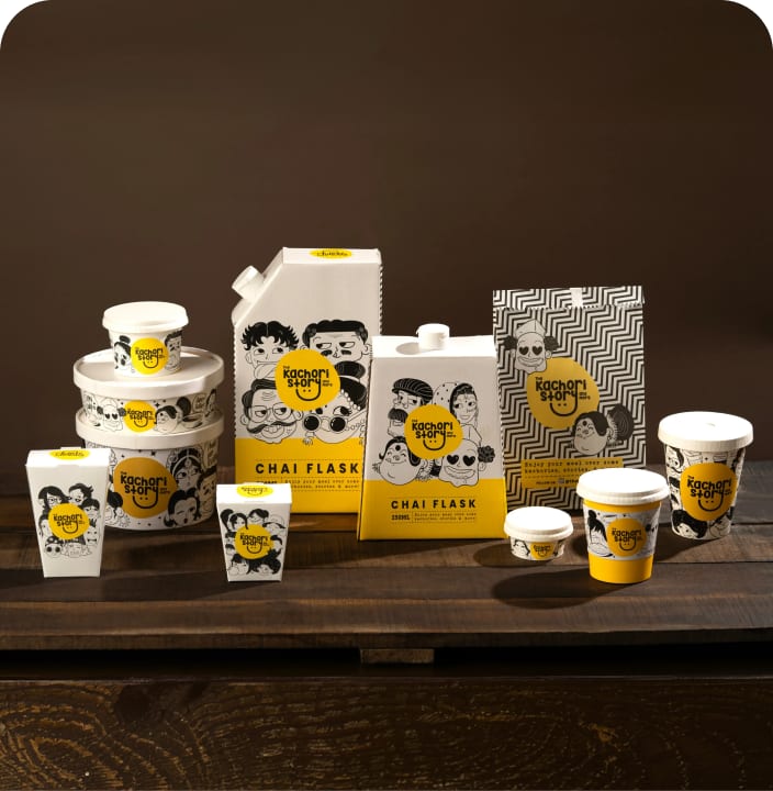 The Kachori Story chai flask packaging, cups, and jars on dark wood